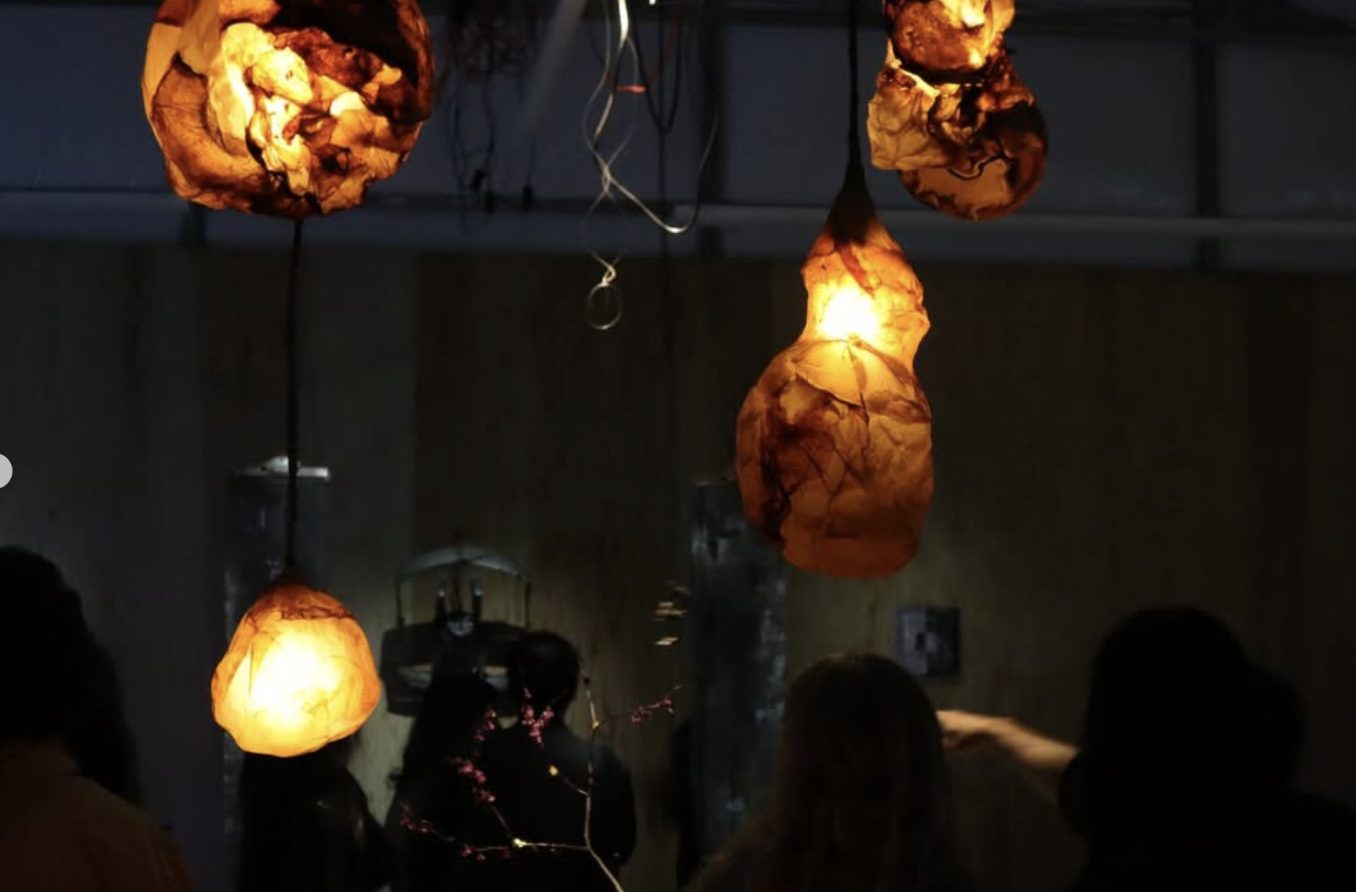 Hanging amber, rock-like lamps glowing above visitors in the dark.
